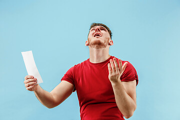 Image showing Young boy with a surprised expression bet slip on blue background