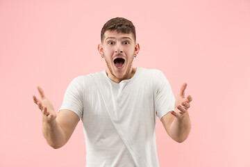 Image showing The young attractive man looking suprised isolated on pink