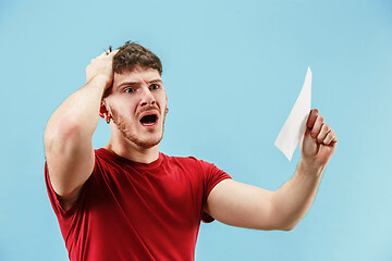 Image showing Young boy with a surprised expression bet slip on blue background