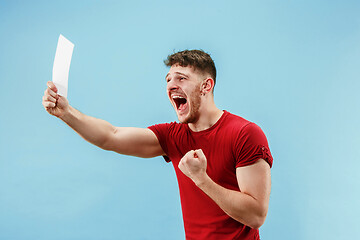 Image showing Young boy with a surprised expression bet slip on blue background