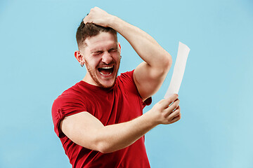 Image showing Young boy with a surprised expression bet slip on blue background