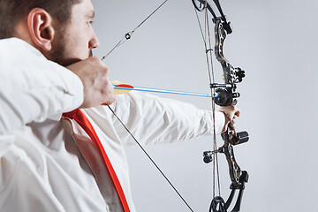 Image showing Businessman aiming at target with bow and arrow, isolated on white background