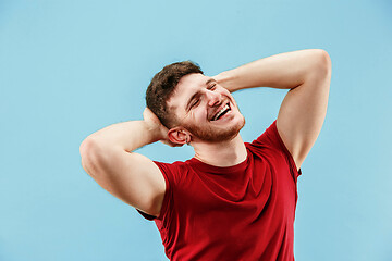 Image showing The happy business man standing and smiling against blue background.