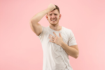 Image showing Beautiful man looking suprised and bewildered isolated on pink