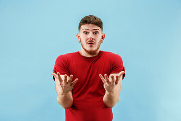 Image showing The young attractive man looking suprised isolated on blue