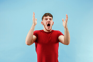 Image showing The young attractive man looking suprised isolated on blue