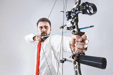 Image showing Businessman aiming at target with bow and arrow, isolated on white background