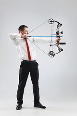 Image showing Businessman aiming at target with bow and arrow, isolated on white background