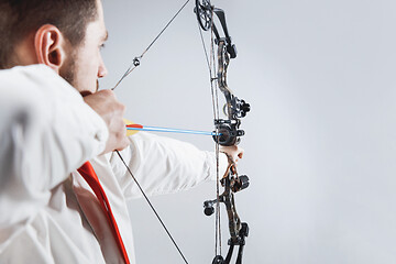 Image showing Businessman aiming at target with bow and arrow, isolated on white background