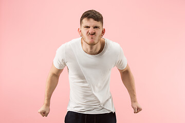 Image showing The young emotional angry man screaming on pink studio background