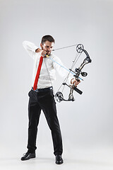 Image showing Businessman aiming at target with bow and arrow, isolated on white background