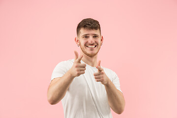 Image showing The happy businessman standing and smiling against pink background.