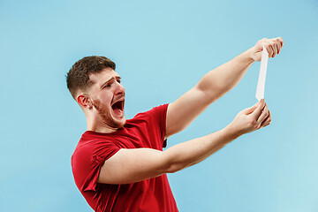 Image showing Young boy with a surprised expression bet slip on blue background