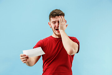 Image showing Young boy with a surprised expression bet slip on blue background