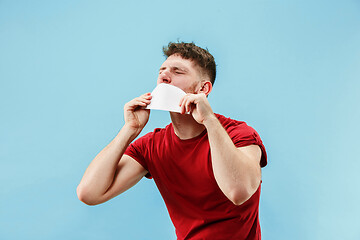 Image showing Young boy with a surprised expression bet slip on blue background