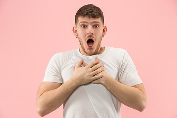 Image showing The young attractive man looking suprised isolated on pink