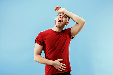 Image showing Man having headache. Isolated over blue background.