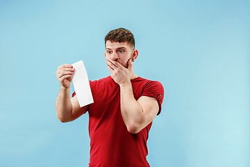 Image showing Young boy with a surprised expression bet slip on blue background