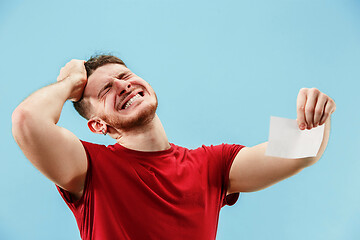 Image showing Young boy with a surprised expression bet slip on blue background