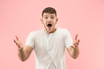 Image showing The young attractive man looking suprised isolated on pink