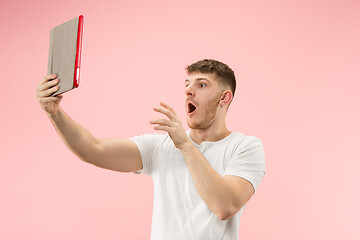 Image showing portrait of smiling man pointing at laptop with blank screen isolated on white