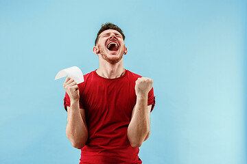 Image showing Young boy with a surprised expression bet slip on blue background