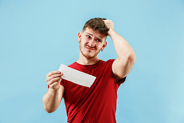 Image showing Young boy with a surprised expression bet slip on blue background