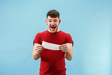 Image showing Young boy with a surprised expression bet slip on blue background