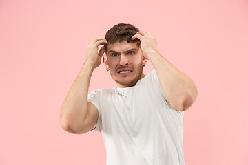 Image showing Beautiful man looking suprised and bewildered isolated on pink