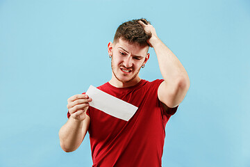 Image showing Young boy with a surprised expression bet slip on blue background