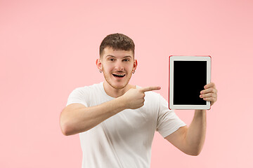 Image showing portrait of smiling man pointing at laptop with blank screen isolated on white