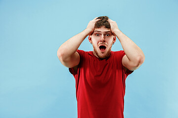 Image showing Young boy with a surprised expression bet slip on blue background