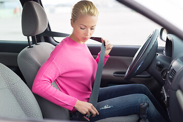 Image showing Beautiful woman fastening seat belt.