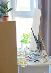 Image showing artist\'s workplace with easel, brushes and paints