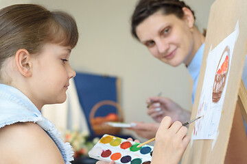 Image showing Teacher looks at how a student draws still life