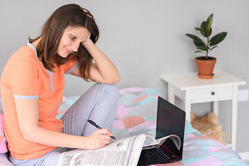 Image showing Girl browsing a newspaper at home and looking for job ads