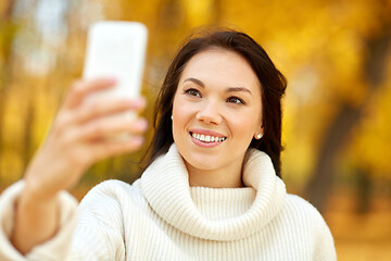 Image showing woman taking selfie by smartphone at autumn park