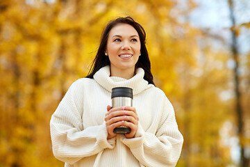 Image showing woman with hot drink in tumbler at autumn park