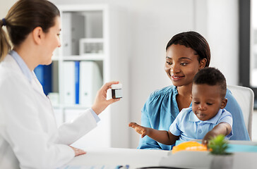 Image showing doctor giving medicine to woman with son at clinic