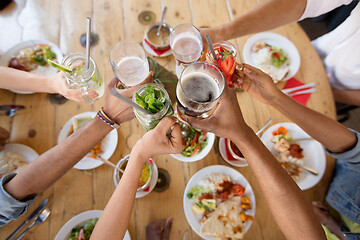 Image showing friends eating and clinking glasses at restaurant