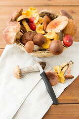 Image showing basket of different edible mushrooms and knife