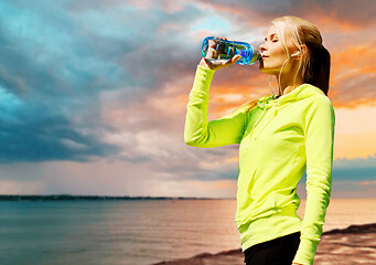 Image showing woman drinking water after exercising at seaside