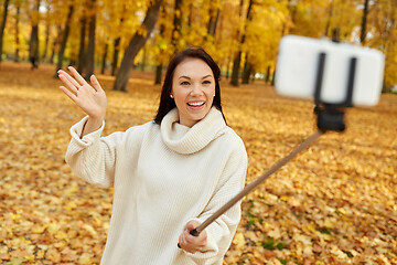 Image showing woman taking selfie by smartphone at autumn park