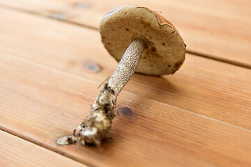 Image showing brown cap boletus mushrooms on wooden background