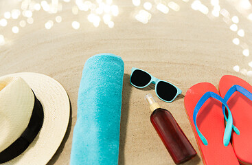 Image showing straw hat, flip flops and sunglasses on beach sand