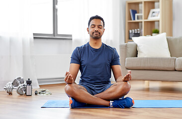 Image showing indian man meditating in lotus pose at home