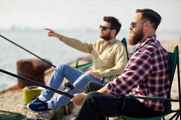 Image showing happy friends with fishing rods on pier