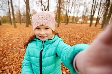 Image showing happy girl taking selfie at autumn park