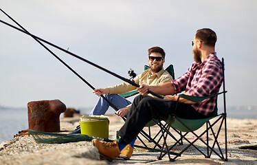 Image showing happy friends with fishing rods on pier