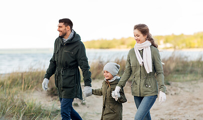 Image showing happy family walking along autumn beach